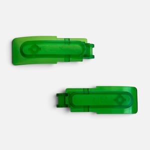 May include: Two translucent green plastic replacement hinges. The top hinge is marked with an L, and the bottom hinge is marked with an R. Each piece features a rectangular base with a central recessed oval channel and a small hinge joint.