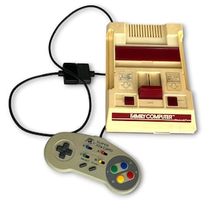 May include: A beige and maroon Family Computer game console with a connected black cable and a grey Super Joy Card controller. The controller features a black directional pad, four colored buttons, and small grey select and start buttons.