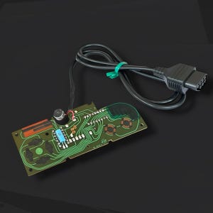 May include: A vintage video game controller circuit board with a black cable and connector. The green circuit board has various components and traces, with a small microphone attached. The cable is secured with a green band.