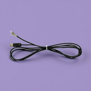 Puede incluir: Un cable USB-C negro con cables expuestos en un extremo, atado con una brida blanca. El cable está enrollado sobre un fondo morado liso.