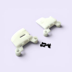 Peut inclure: Deux composants en plastique blanc cassé de forme incurvée, percés de trous et d'une fente, sont présentés avec un ensemble de petites vis noires. Les articles sont posés sur un fond violet clair et doux.
