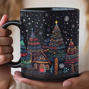 May include: A black ceramic mug featuring a colorful dot-art illustration of a winter scene with decorated pine trees, a small house, and falling snowflakes. The design uses vibrant points of light to depict a festive night landscape.