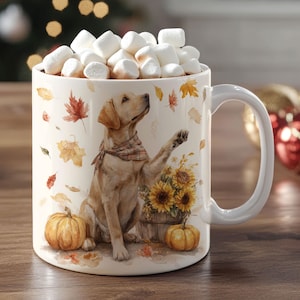May include: A white ceramic mug filled with marshmallows, featuring a Labrador Retriever illustration with sunflowers, pumpkins, and autumn leaves. The mug has a white handle and is perfect for hot beverages.