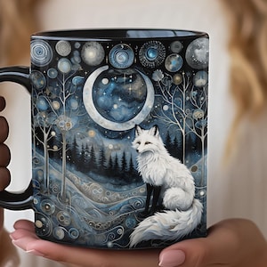 May include: Black ceramic mug with a white fox standing in a snowy forest scene. The background features a crescent moon with stars and swirling patterns.