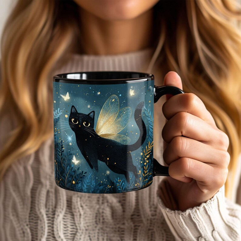 May include: Black ceramic mug featuring a whimsical illustration of a black cat with golden fairy wings, set against a dark blue background with stars and butterflies. The mug has a black handle and rim, perfect for coffee or tea.