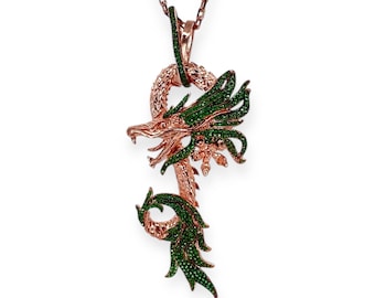 May include: A rose gold dragon pendant necklace with green gemstone accents. The dragon features intricate detailing, with a serpentine body and outstretched wings. The pendant hangs from a delicate chain, creating a striking piece of jewelry.