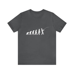 May include: A dark gray t-shirt with a white graphic of the evolution of man, ending with a man holding a fishing rod.