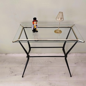 Mesa auxiliar antigua de cristal y metal.