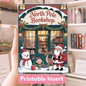 May include: A clear phone case with a festive design featuring a Christmas scene. The image shows a bookstore with the text "North Pole Bookshop", a snowman, Santa Claus, an elf, and a reindeer. The words "Printable Insert" are at the bottom.
