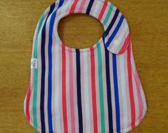 May include: A colorful striped baby bib with a white button. The bib is made of soft fabric and has a pink, blue, green, and white striped pattern.