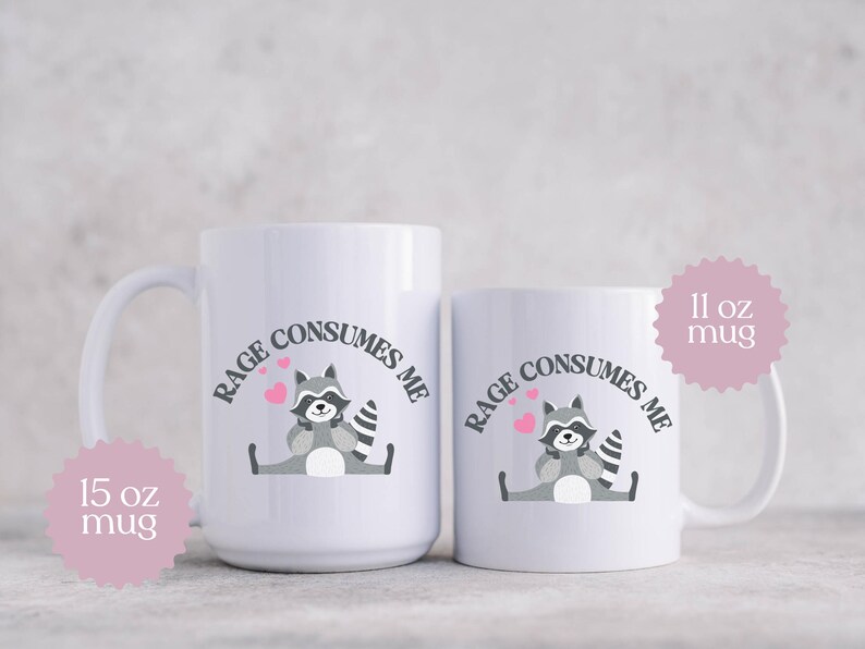 Peut inclure: Deux tasses en c&eacute;ramique blanche avec un graphique de raton laveur noir et gris et le texte "Rage Consumes Me". La tasse la plus petite est de 11 oz et la tasse la plus grande est de 15 oz.
