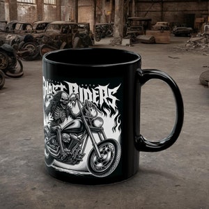 以下が含まれることがあります： 炎が燃え盛るバイクに乗った骸骨の白いグラフィックが描かれた黒いセラミックマグカップ。マグカップには「ゴーストライダー」の文字が印刷されています。
