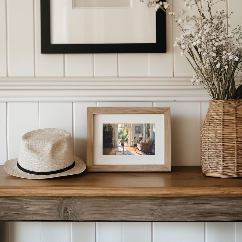 May include: A framed print of a painting depicting two children running through a doorway into a sunlit room. The print is displayed on a wooden shelf with a straw hat and a vase of white flowers.