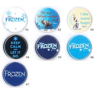 May include: Seven circular pin-back buttons featuring Disney Frozen themes. Designs include the Frozen Jr. logo, Sven with text, Olaf with the text I like warm hugs, Keep Calm and Let It Go, Frozen Kids logos in blue and dark blue, and the Frozen musical logo.