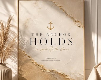 May include: A rectangular wall art print featuring a textured cream and gold abstract background. Centered is a gold anchor icon above the black text THE ANCHOR HOLDS in spite of the storm, followed by PSALM 62:6 He alone is my rock and my salvation.