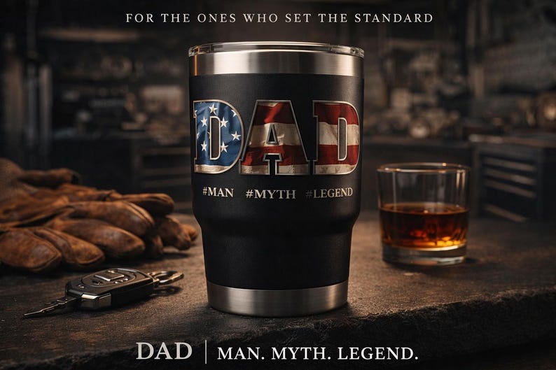 K&ouml;nnte beinhalten: Schwarzer Becher mit dem Wort "DAD" in einem patriotischen Design. Der Becher hat einen Edelstahlrand und -boden. Das Bild enth&auml;lt auch einen Whiskey-Shot, Arbeitshandschuhe und einen Autoschl&uuml;ssel. Auf dem Becher steht: #MAN #MYTH #LEGEND.