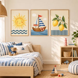 Puede incluir: Tres cuadros de pared enmarcados que muestran un sol amarillo sonriente sobre olas azules, un velero con una bandera roja sobre agua azul y una rama con dos limones amarillos y flores blancas sobre un patrón de rayas verticales azules y blancas.
