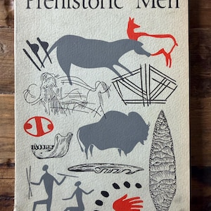 May include: A vintage book cover titled "Prehistoric Men" with illustrations of cave paintings. The cover features gray silhouettes of animals, humans, and tools, with red and black accents. The background is a light beige color.