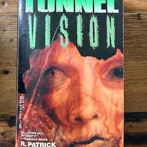 May include: A paperback book titled "Tunnel Vision" with a grotesque, close-up image of a face on the cover. The title is in large, green, stylized letters. The author's name, R. Patrick Gates, is also visible.