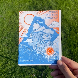 May include: A blue and orange illustrated comic book cover with the title "WHEN THE SUN COMES UP". The cover features two characters, one with a red sun behind them and the other holding a red star.