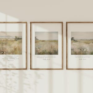 May include: Three framed landscape prints with a serene meadow scene in muted tones. Each print features a different Bible verse in a classic serif font. The frames are a warm, natural wood color, adding to the rustic aesthetic.