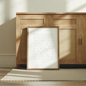 May include: A rectangular wall art print in a brown wooden frame featuring the text of Psalm 23 written in a light gray cursive script on a white background. The print is positioned upright, displaying the full biblical passage clearly.