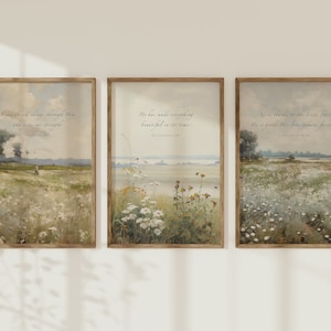May include: Three framed landscape art prints with inspirational quotes. The prints depict pastoral scenes with fields of wildflowers and soft, muted colours. Each frame has a wooden appearance. The text includes: "I can do all things through Him", "He has made everything beautiful", and "Give thanks to the Lord".