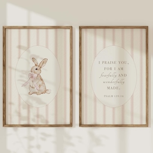 May include: Two framed prints with a pink and white striped background. The left print features a watercolour illustration of a brown bunny with a pink bow. The right print features a quote from Psalm 139:14, "I praise you, for I am fearfully and wonderfully made."