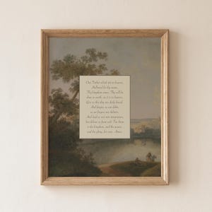 May include: Framed artwork featuring a landscape painting with a light-colored rectangle in the center. The rectangle contains the text of a prayer. The frame is made of light brown wood.