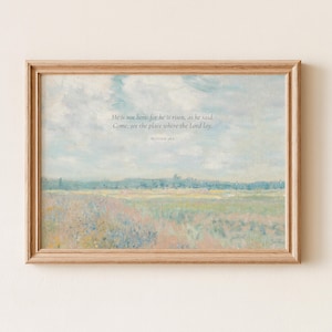 May include: A framed landscape print featuring a soft-toned field under a cloudy sky. The text reads: He is not here: for he is risen, as he said. Come, see the place where the Lord lay. Matthew 28:6. The frame is a light-colored wood.