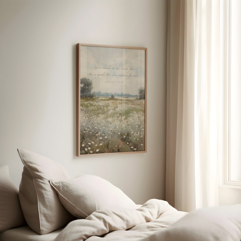 May include: A framed landscape print featuring a field of white flowers and trees under a cloudy sky. The print includes the text "Give thanks to the Lord, for He is good; His love endures forever. 1 Chronicles 16:34."
