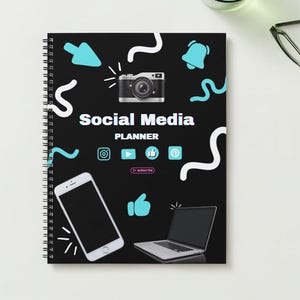 May include: A black spiral bound notebook with a social media planner design. The cover features a camera, a smartphone, a laptop, and various social media icons. The text "Social Media Planner" is printed in white on the cover.