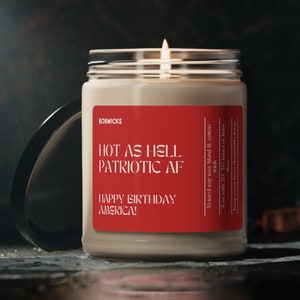 May include: A red and white candle with the text "HOT AS HELL PATRIOTIC AF HAPPY BIRTHDAY AMERICA!"  The candle is in a clear glass jar with a lid.