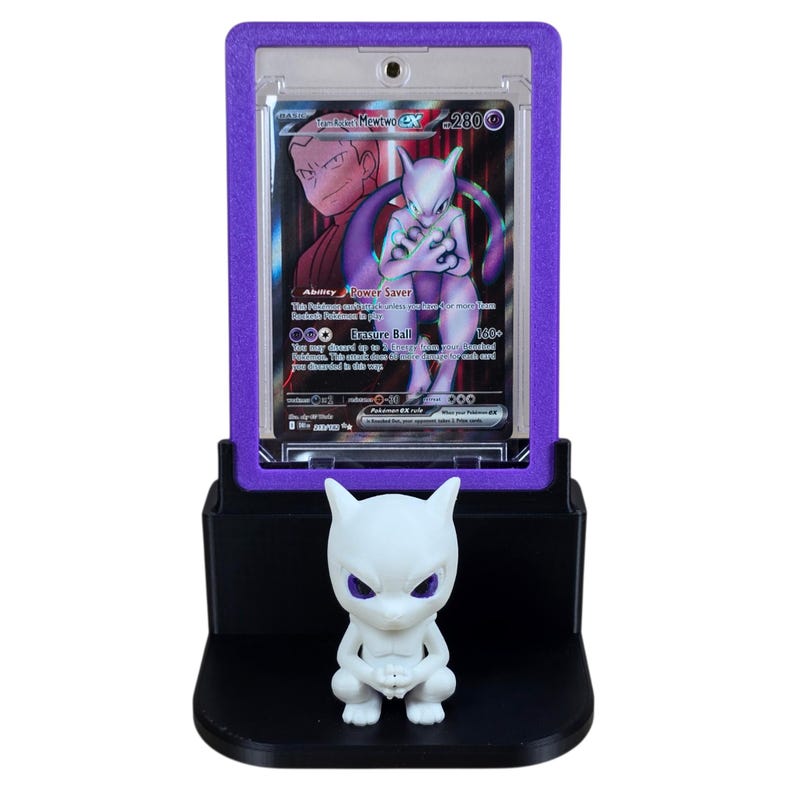 May include: A purple and black display stand holding a Pok&eacute;mon trading card featuring Mewtwo EX. A white Mewtwo figurine sits on the base of the stand. The card is encased in a purple frame.