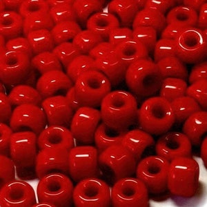 May include: A large pile of bright red round plastic beads. All the beads are the same size and shape.