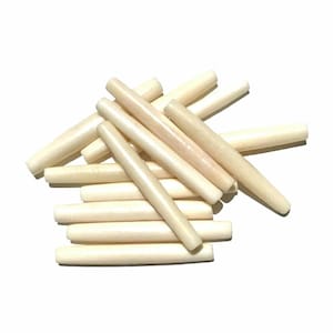 May include: A pile of off-white, smooth, cylindrical beads. The beads are made of bone and are approximately 1 inch in length.