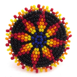 May include: A circular beaded design with a black, red, yellow, orange, and blue color scheme. The beads are arranged in a spiral pattern, creating a visually appealing and intricate design.