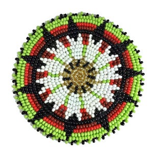 May include: A round, beaded coaster with a detailed, symmetrical design. The coaster features a central gold-colored circle surrounded by white, red, black, and green beads. The outer edge is lined with green beads.