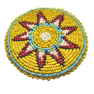 May include: A round beaded sun design with yellow, red, white, black, and blue beads.