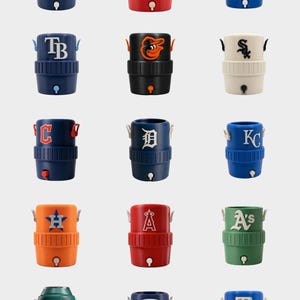 Pode incluir: Cole&ccedil;&atilde;o de refrigeradores de bebidas isolados em v&aacute;rias cores, cada um com o logotipo de uma equipa da Major League Baseball. Os refrigeradores t&ecirc;m formato cil&iacute;ndrico com torneira e al&ccedil;as.