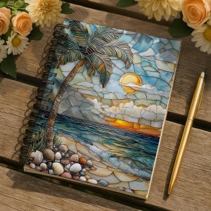May include: Spiral-bound notebook featuring a beach scene with a palm tree, ocean, and sunset. The cover has a mosaic-like design with blue, yellow, and brown colors. A gold pen rests beside the notebook on a wooden surface.