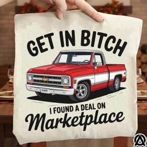 May include: A beige cushion featuring the text "GET IN BITCH" above a red and white vintage pickup truck illustration. Below the truck, the text reads "I FOUND A DEAL ON Marketplace". The cushion is held up by a hand.