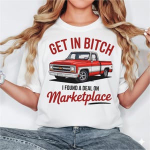Op de afbeelding: Wit T-shirt met een afbeelding van een rood-witte vintage pick-up truck. De tekst boven de truck luidt "GET IN BITCH", en daaronder "I FOUND A DEAL ON Marketplace". Het ontwerp is gedrukt op een wit T-shirt.