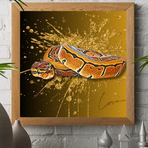Op de afbeelding: Een ingelijste print met een gedetailleerde illustratie van een koningspython. De slang is afgebeeld met oranje, bruine en zwarte markeringen tegen een goud-zwarte gradiënt achtergrond met gouden spetters. Het woord "Love" is cursief geschreven.
