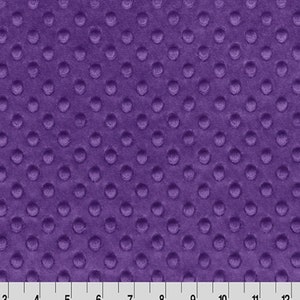 May include: Purple minky fabric with a textured dot pattern. The fabric is soft and plush, making it ideal for blankets, baby clothes, and other crafts.