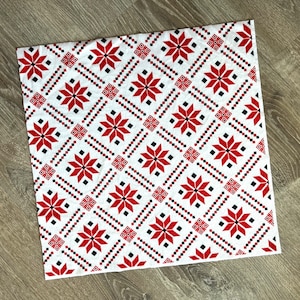 May include: White fabric with a red and black geometric pattern. The pattern is a repeating design of diamonds and stars.