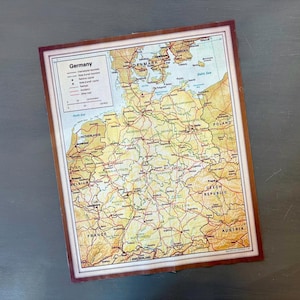 May include: A vintage map of Germany with a brown border. The map shows the country's borders, major cities, and state boundaries. The map is labeled "Germany" in the top left corner.
