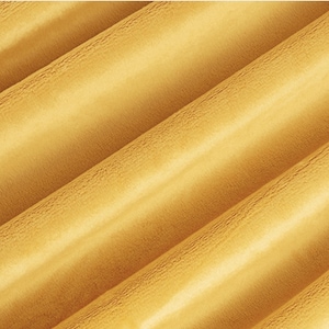 May include: Close-up of a textured, golden-yellow fabric with diagonal, rounded ridges. The fabric has a soft, slightly fuzzy appearance, with subtle variations in color and texture, creating a sense of depth and dimension.