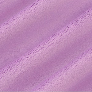 May include: Close-up of a soft, plush fabric in a light purple color. The fabric has a subtle texture and a slightly fuzzy appearance.