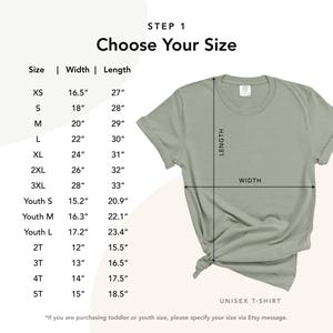 May include: A sage green unisex t-shirt with size chart. The chart shows width and length measurements in inches for sizes XS to 3XL, and youth sizes. The text "Choose Your Size" is at the top. The shirt is knotted at the bottom.